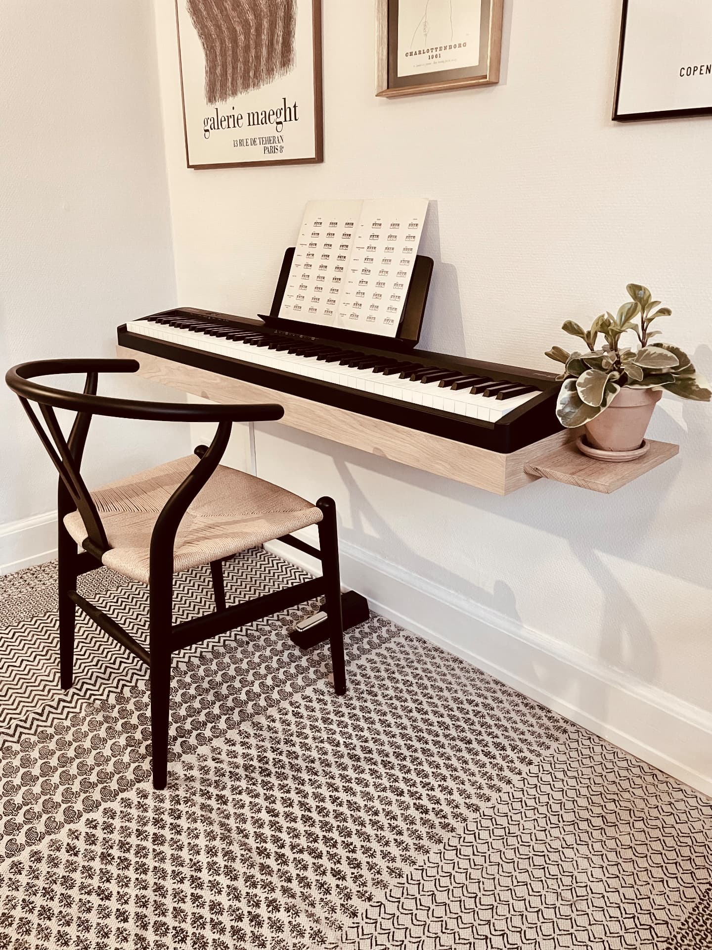 Solid oak Floating Piano Frame wall-mounted with a Roland FP digital piano and a wishbone chair in a Scandinavian living room