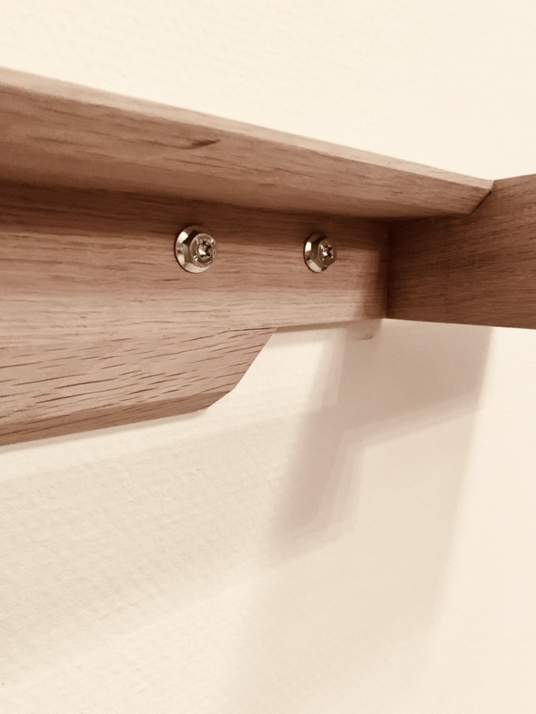 Wall mount bracket detail of a solid oak Floating Piano Frame during installation